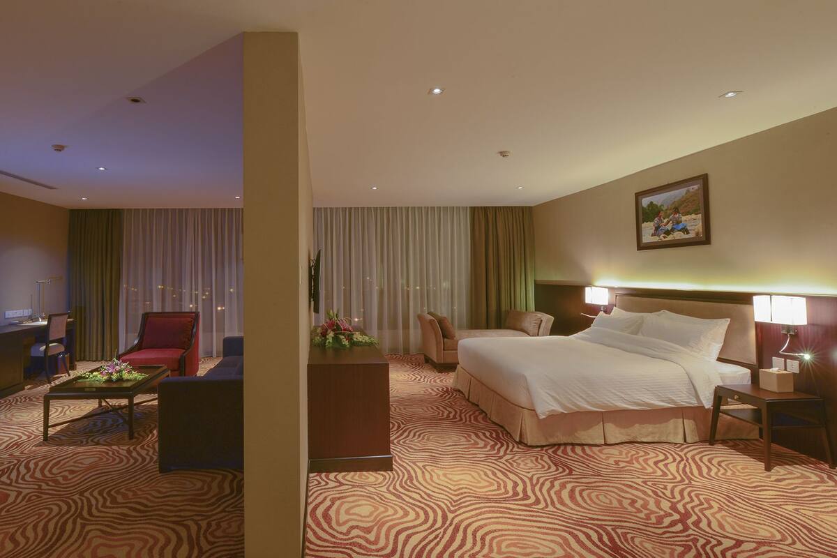 Een hotelkamer met een bed, een bureau, een televisie en een stoel.