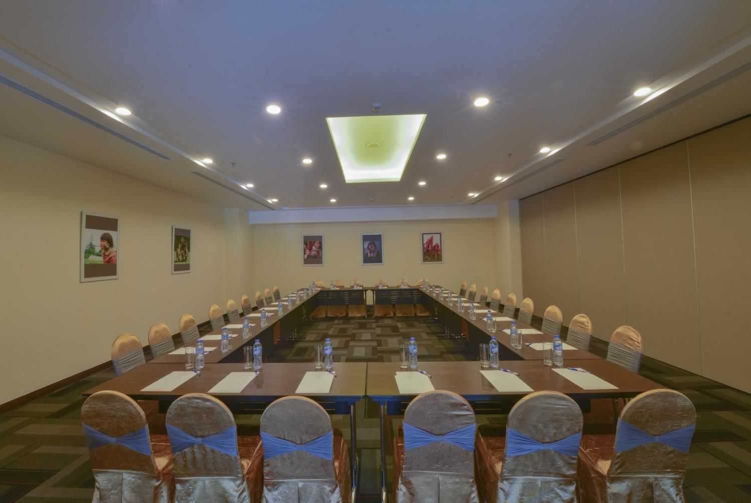 A conference room with a long table, chairs, and a ceiling light.