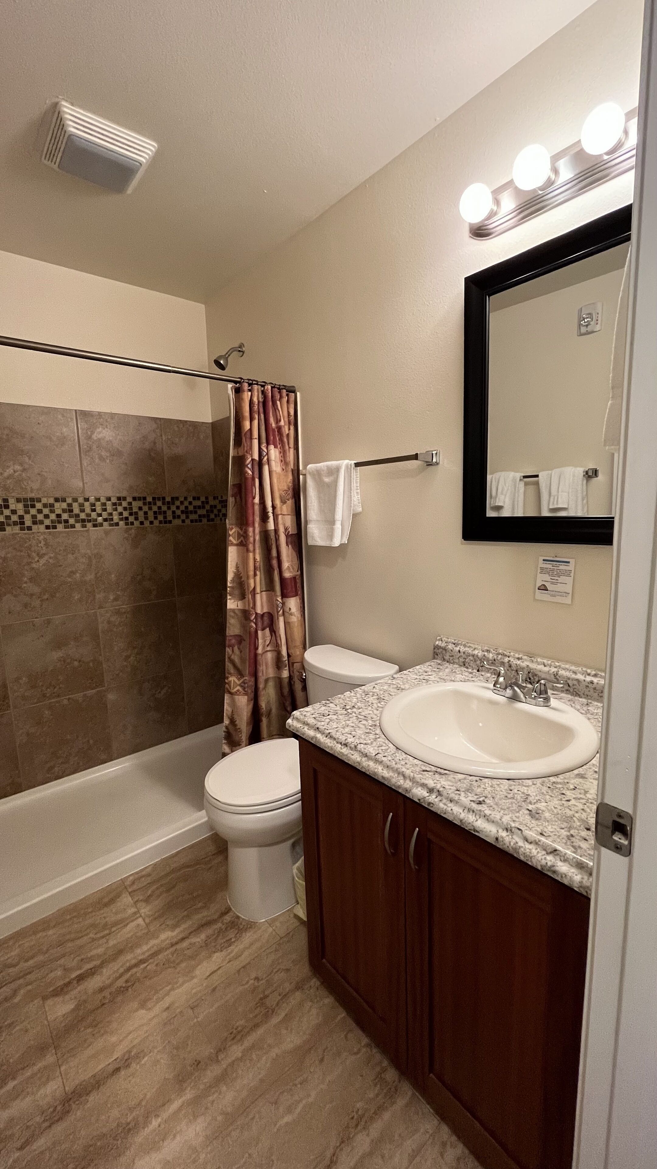 Une salle de bain équipée d’une douche, de toilettes, d’un lavabo et d’un meuble-lavabo.