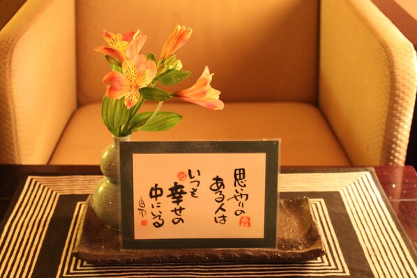 Una mesa con un florero y un cartel en caracteres japoneses.