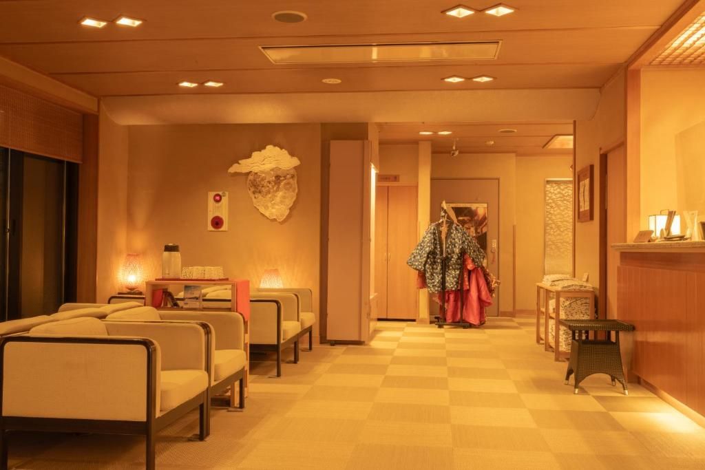 A hotel lobby with seating areas, a reception desk, and a coat rack.