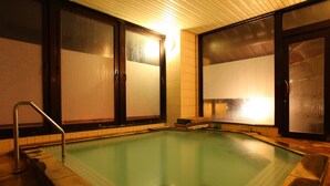 Una piscina con paredes de azulejos y una escalera de metal.