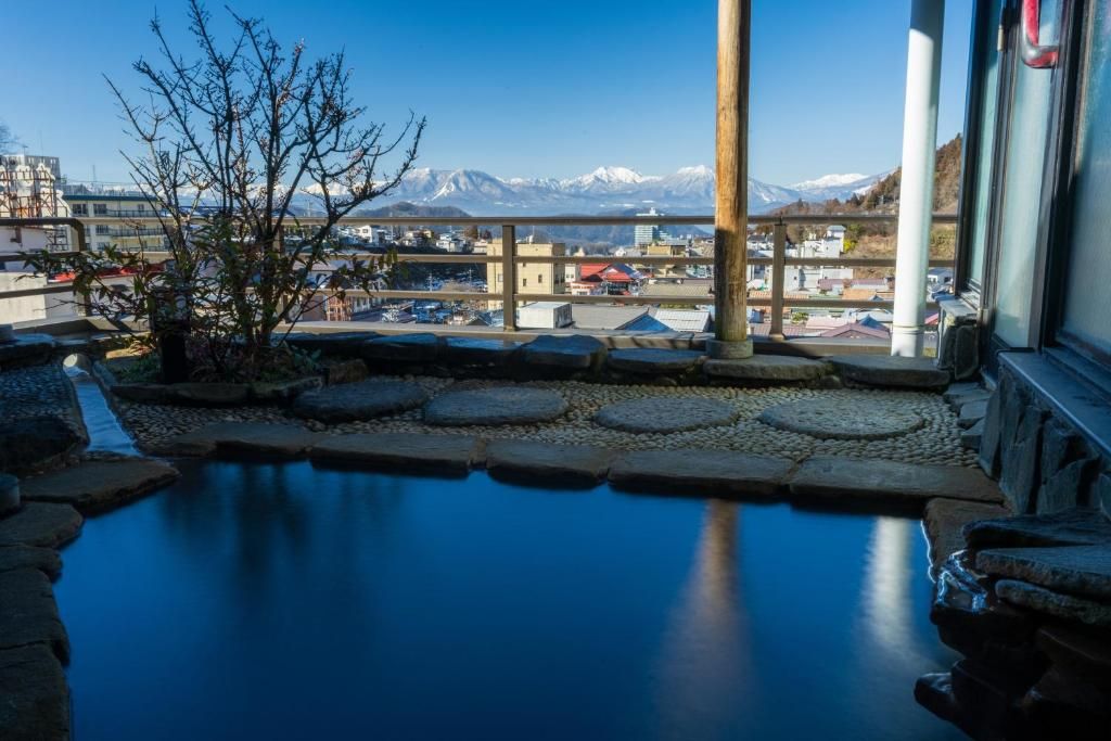 A pool with stone steps and a view of mountains in the background.