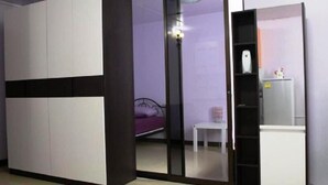 Un dormitorio con cama, una mesita y un armario.