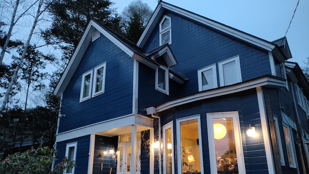 A two-story house with a porch, large windows, and a visible door. - Bellscabin Guesthouse (Karuizawa)