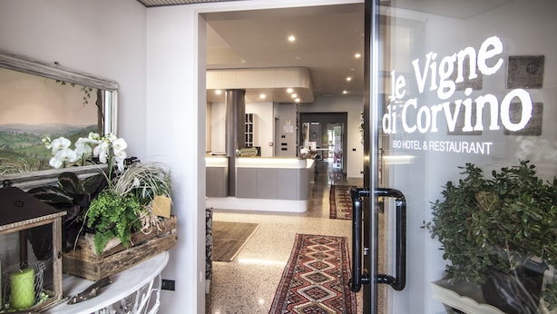 A hotel entrance with a reception desk, a view of the interior, and a sign reading "Le Vigne di Corvino Bio Hotel & Restaurant". - Hotel Le Vigne di Corvino (Corvino San Quirico)