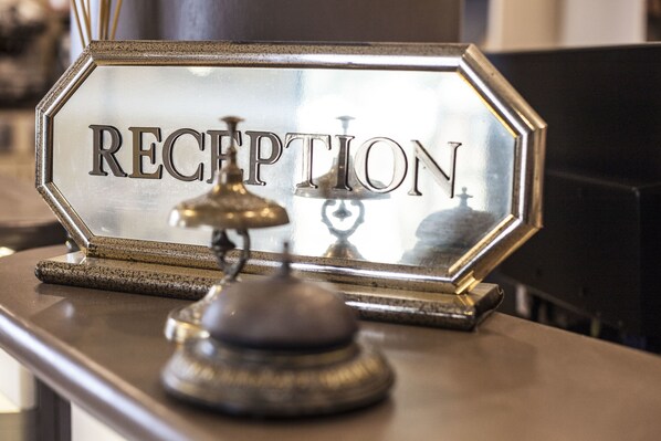 A reception desk with a sign that reads "RECEPTION" and a bell.