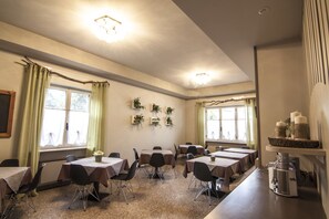 A dining area with tables and chairs, a coffee machine, and decorative plants on the walls. - Hotel Le Vigne di Corvino (Corvino San Quirico)
