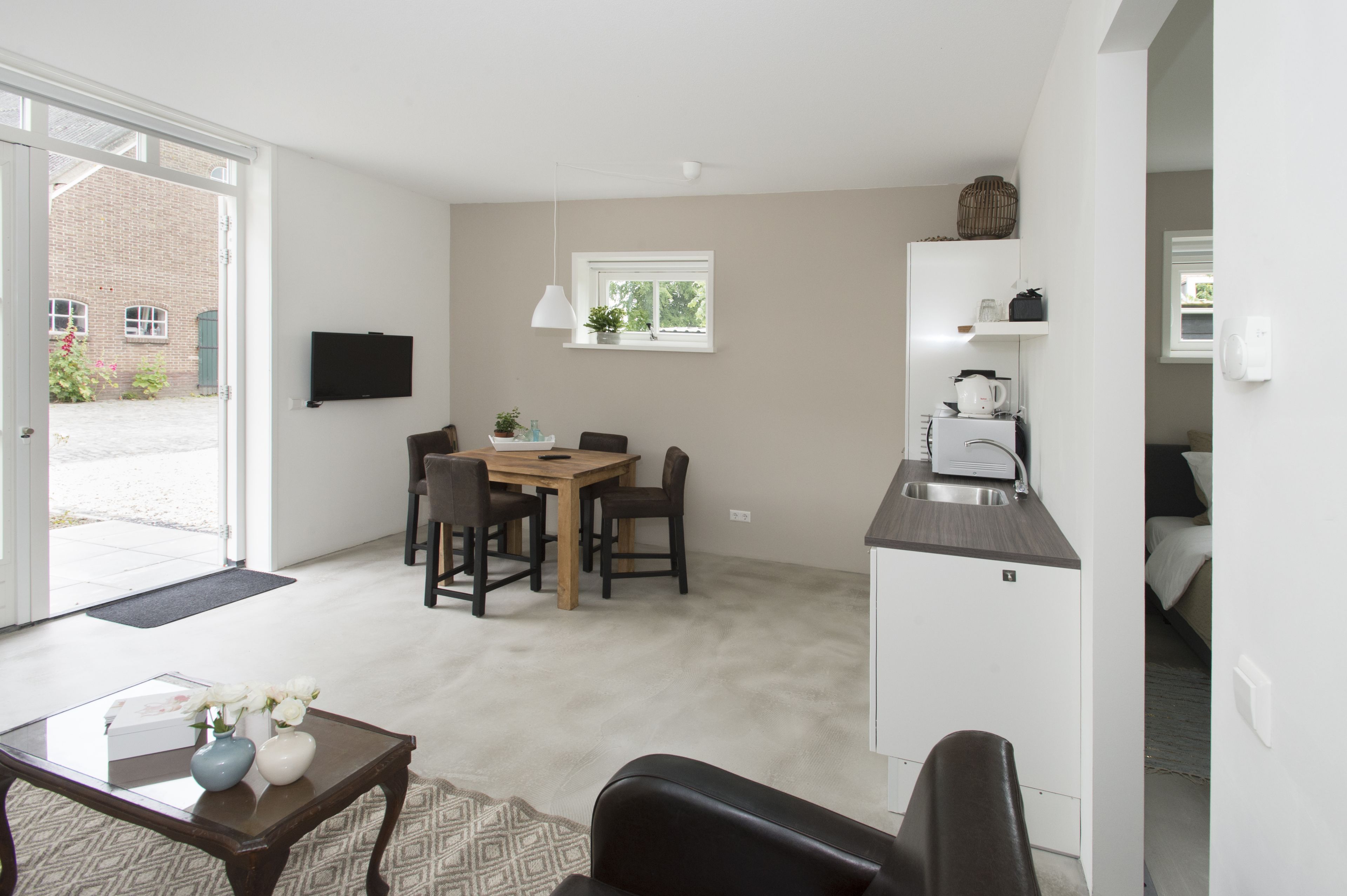 A compact living space with a dining area, kitchenette, and a small seating area.