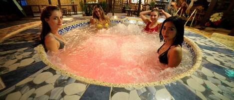 A hot tub with a tiled floor and a group of people around it.