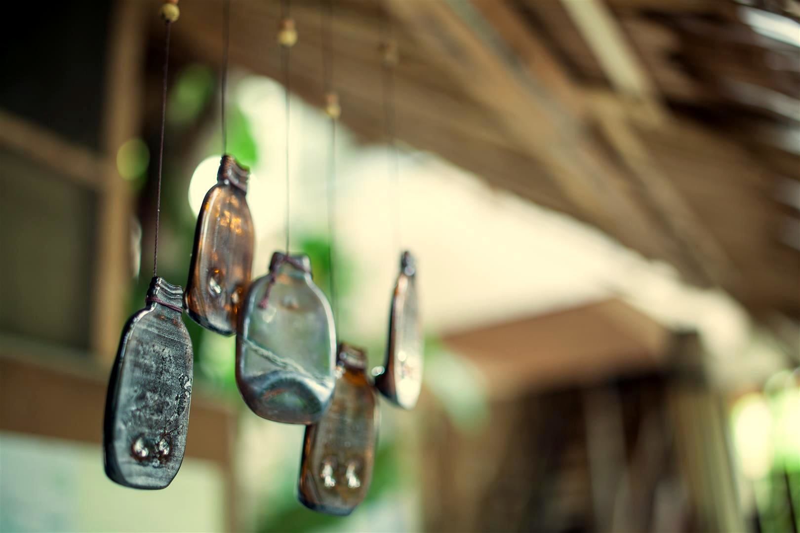 A close-up of hanging glass bottles with a blurred background.