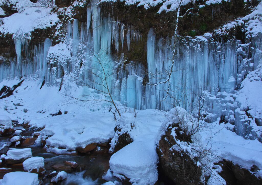 A frozen waterfall with icicles hanging from the cliff.