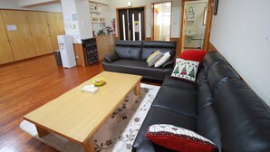 A living room with a sofa, a coffee table, and a wooden floor.