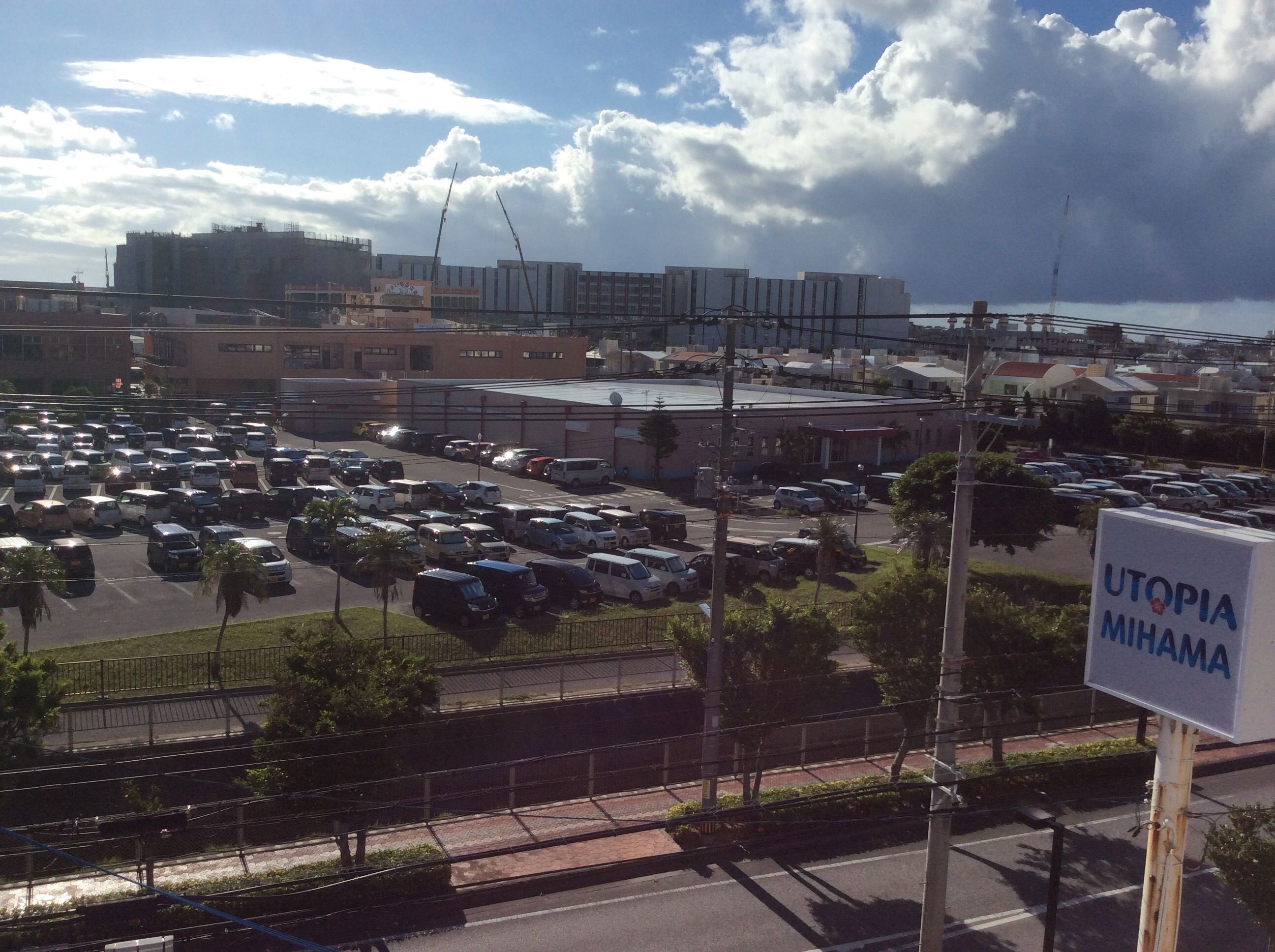 A parking lot with multiple cars and a sign that reads "UTOPIA MIHAMA".