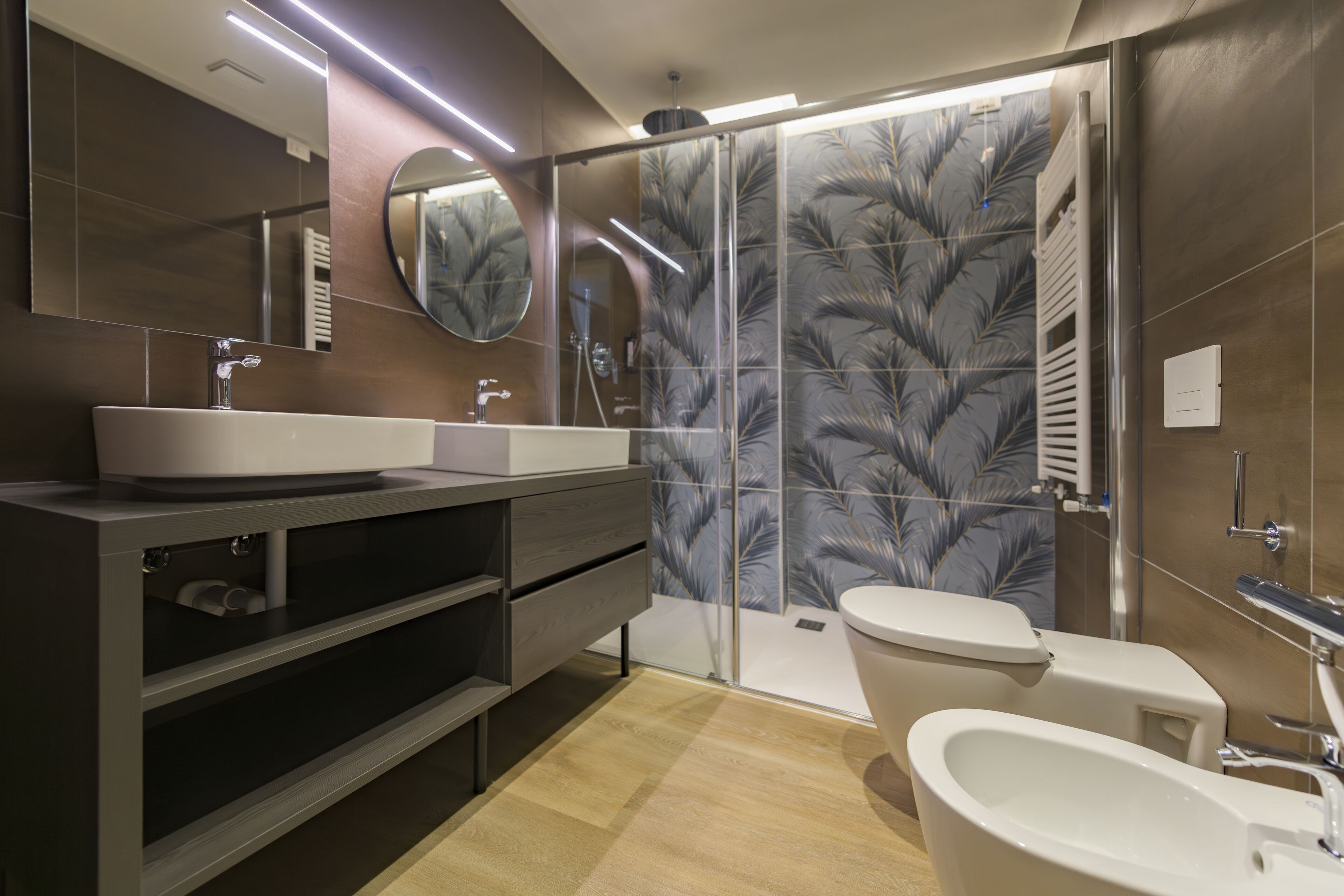 A modern bathroom with a large mirror, a sink, a toilet, and a shower area.
