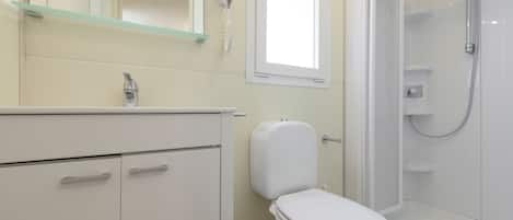 A modern bathroom with a toilet, sink, and shower.