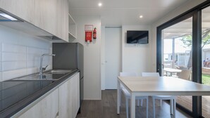 Une cuisine moderne équipée d’une cuisinière intégrée, d’un évier et d’un coin repas avec une table et des chaises.