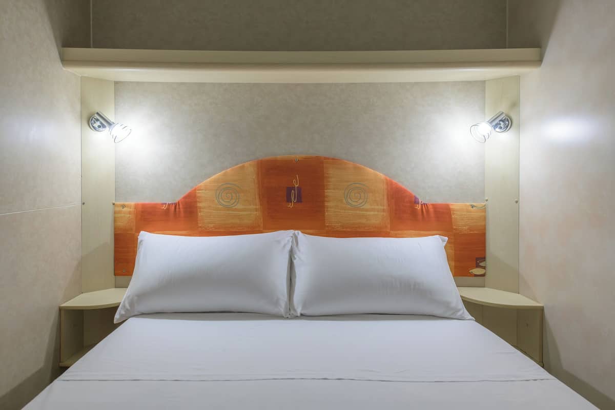 Ein Hotelzimmer mit einem Bett, zwei Nachttischen und einem Kopfteil mit einem besonderen Design.