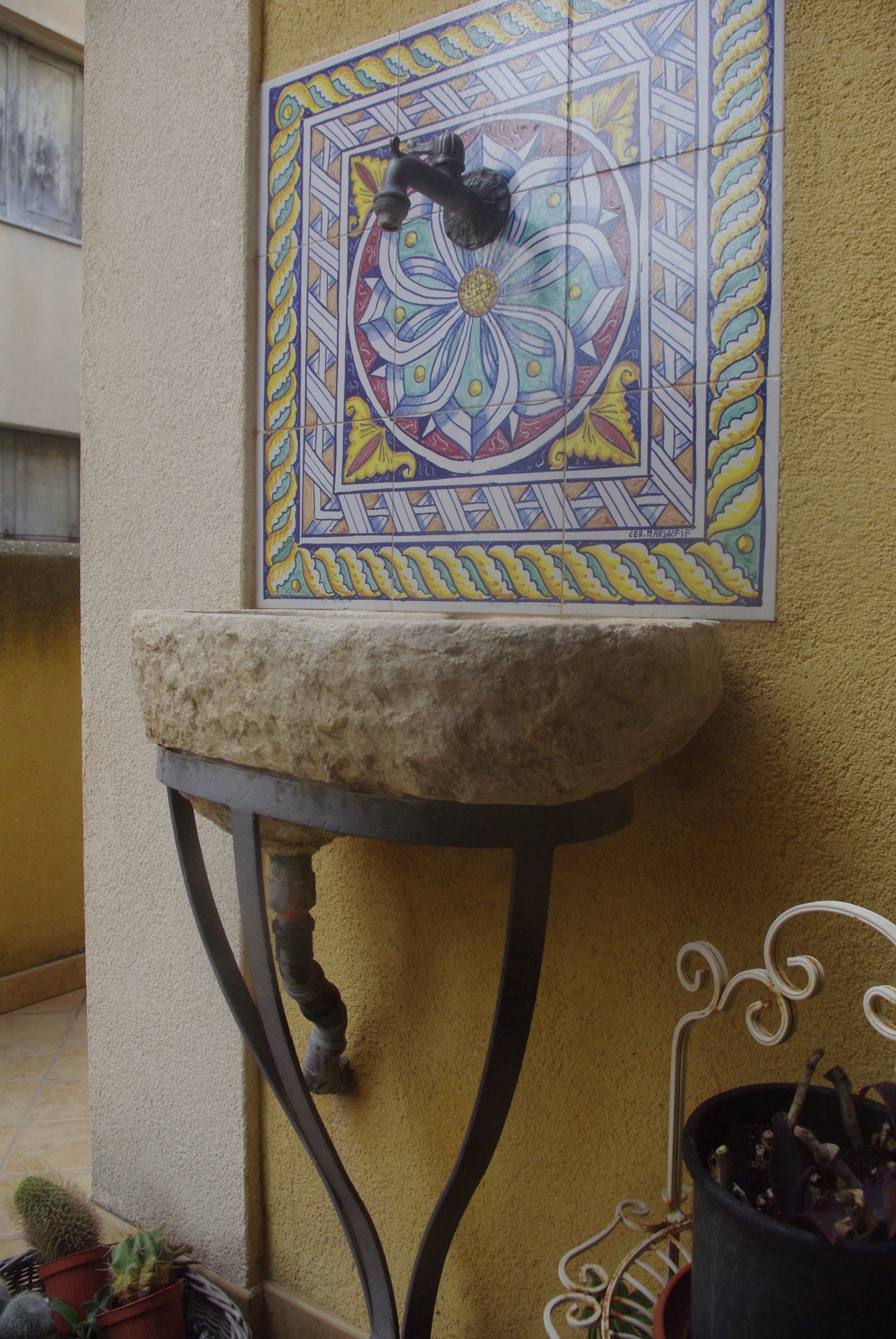Un mur recouvert de carreaux, dont un carreau décoratif présente un motif géométrique.