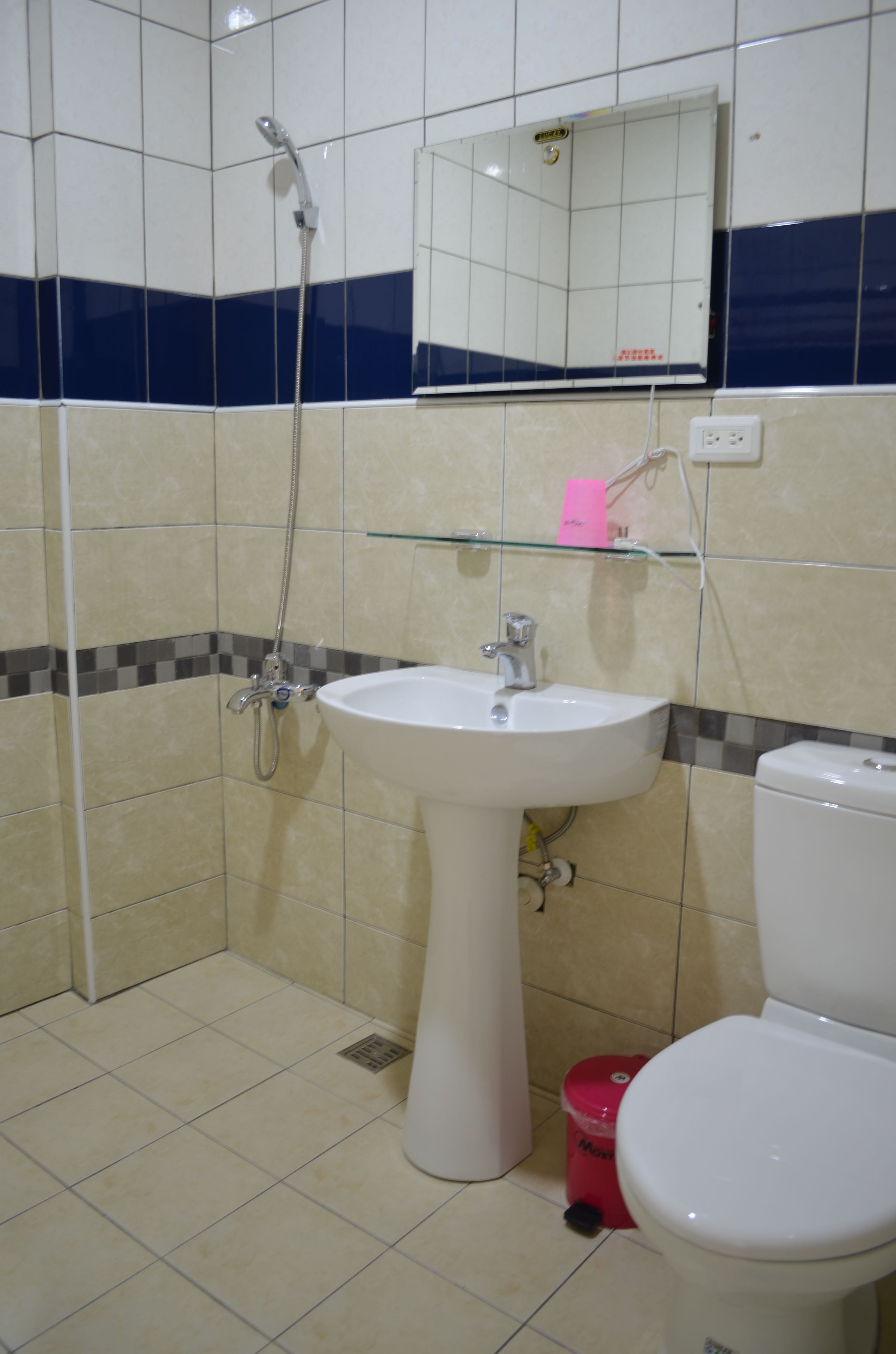 Un baño con lavamanos blanco, inodoro y ducha.