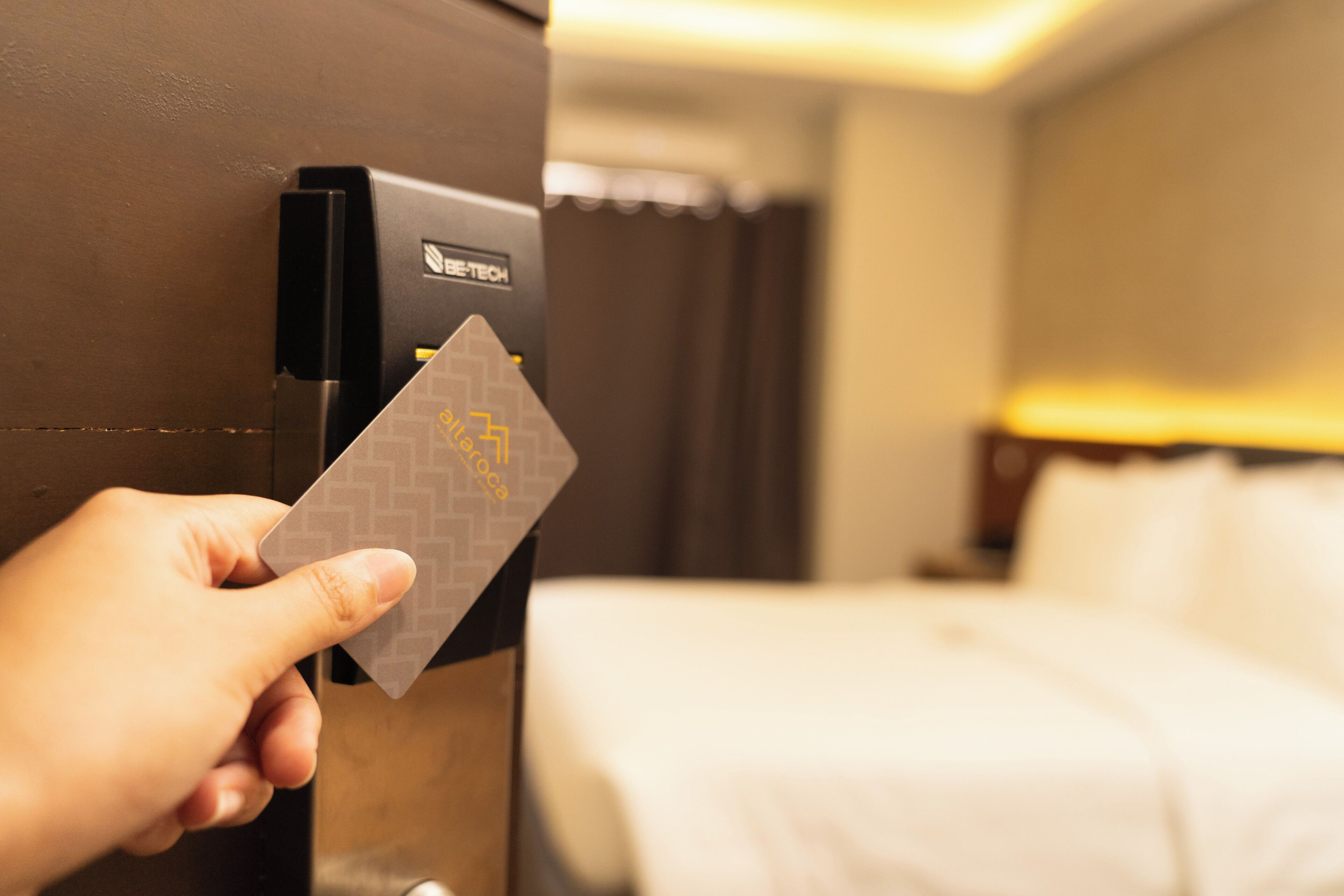 A hand inserting a card into a card reader in a hotel room.