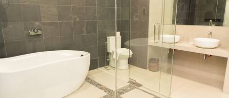 Un baño moderno con una bañera independiente, ducha con mampara de vidrio y tocador doble.