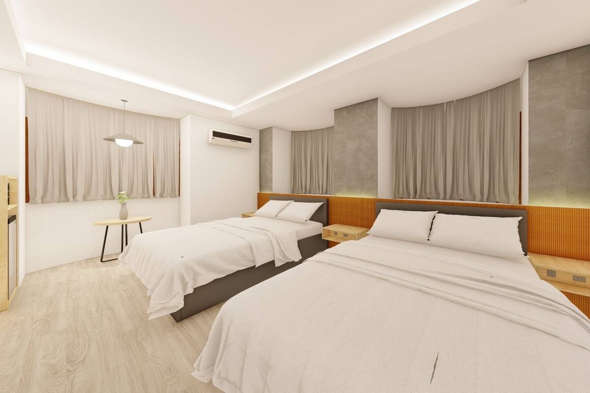 Une chambre d’hôtel moderne avec deux lits, une petite table et une fenêtre avec des rideaux.