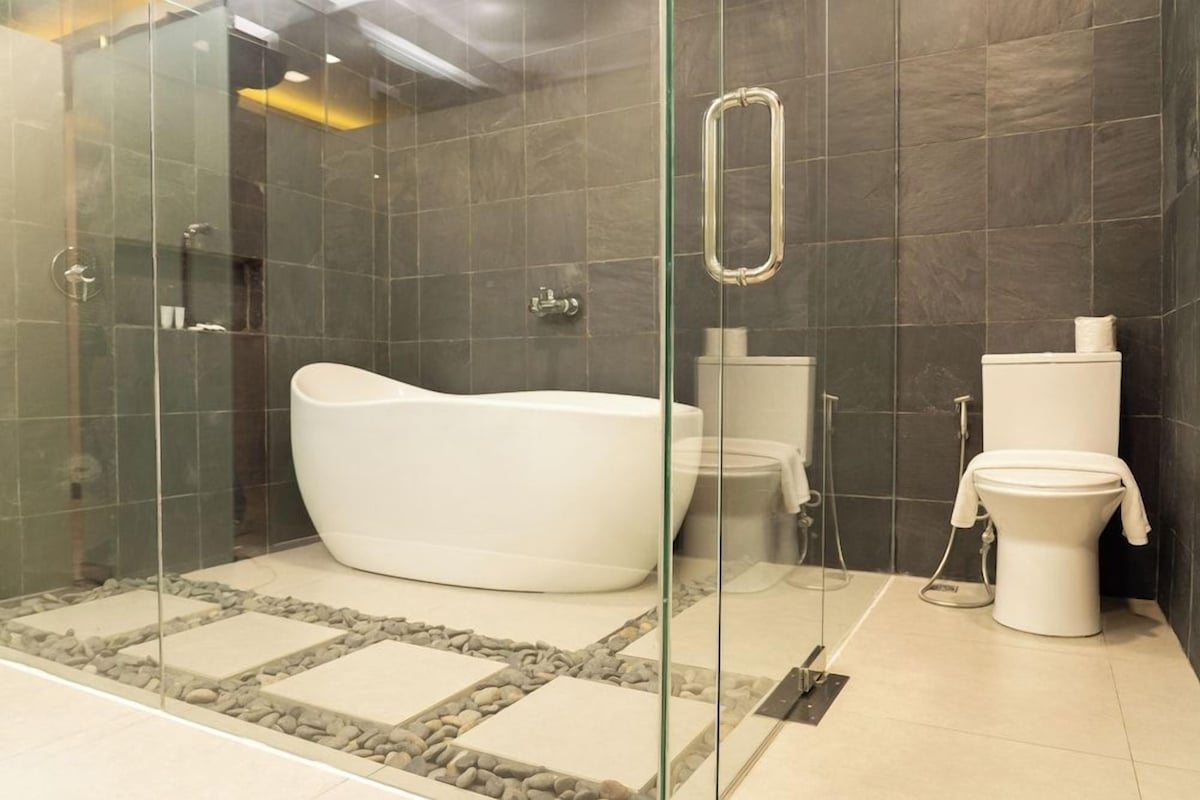 Ein modernes Badezimmer mit einer Glasdusche, einer freistehenden Badewanne und einem WC.