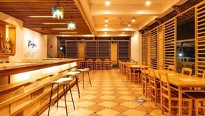Una zona de bar con taburetes, una barra y un suelo a cuadros.