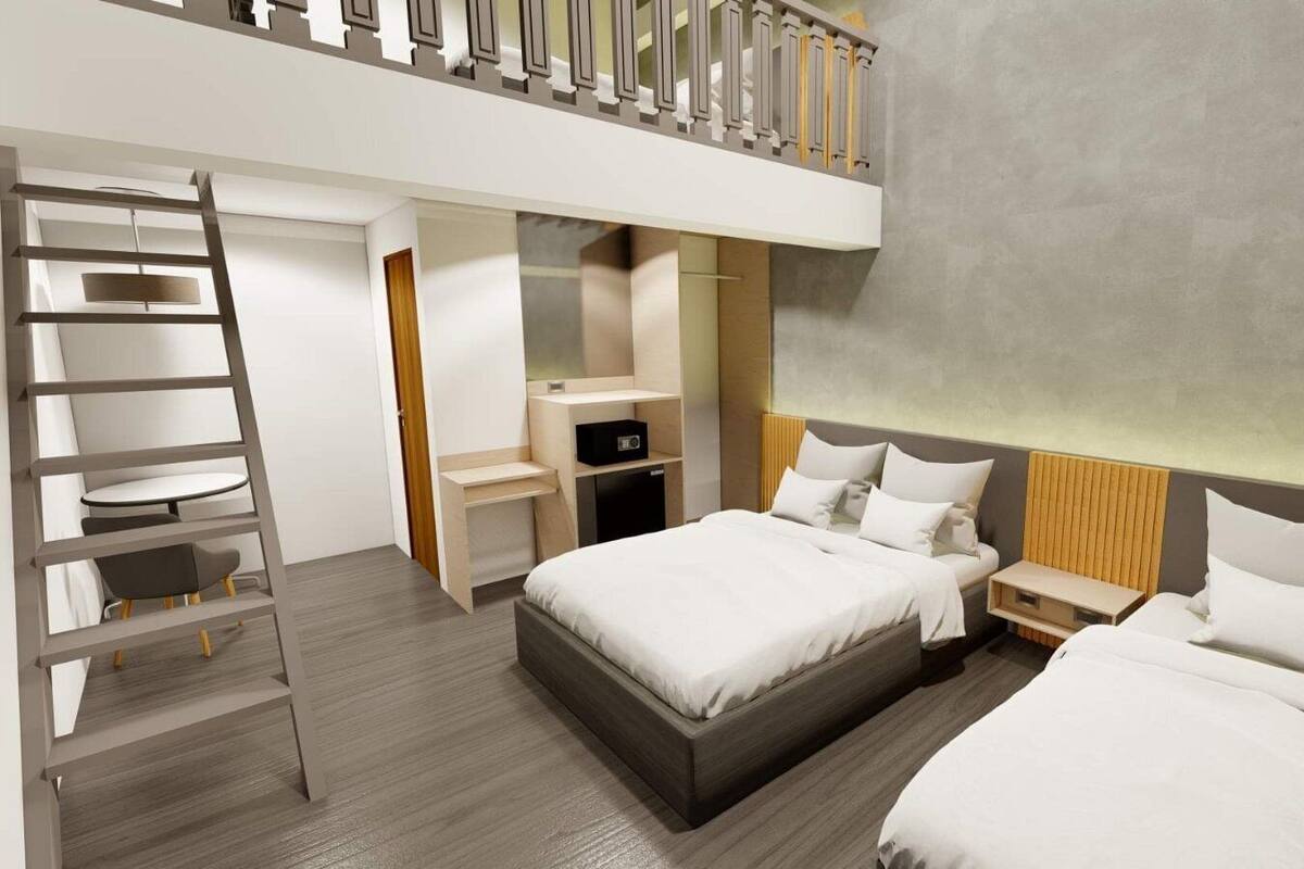 Une chambre d’hôtel moderne dotée d’un espace nuit en mezzanine, d’un bureau et d’une armoire.