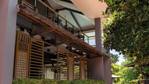 Un edificio moderno con un espacio exterior techado, una escalera y una barandilla.