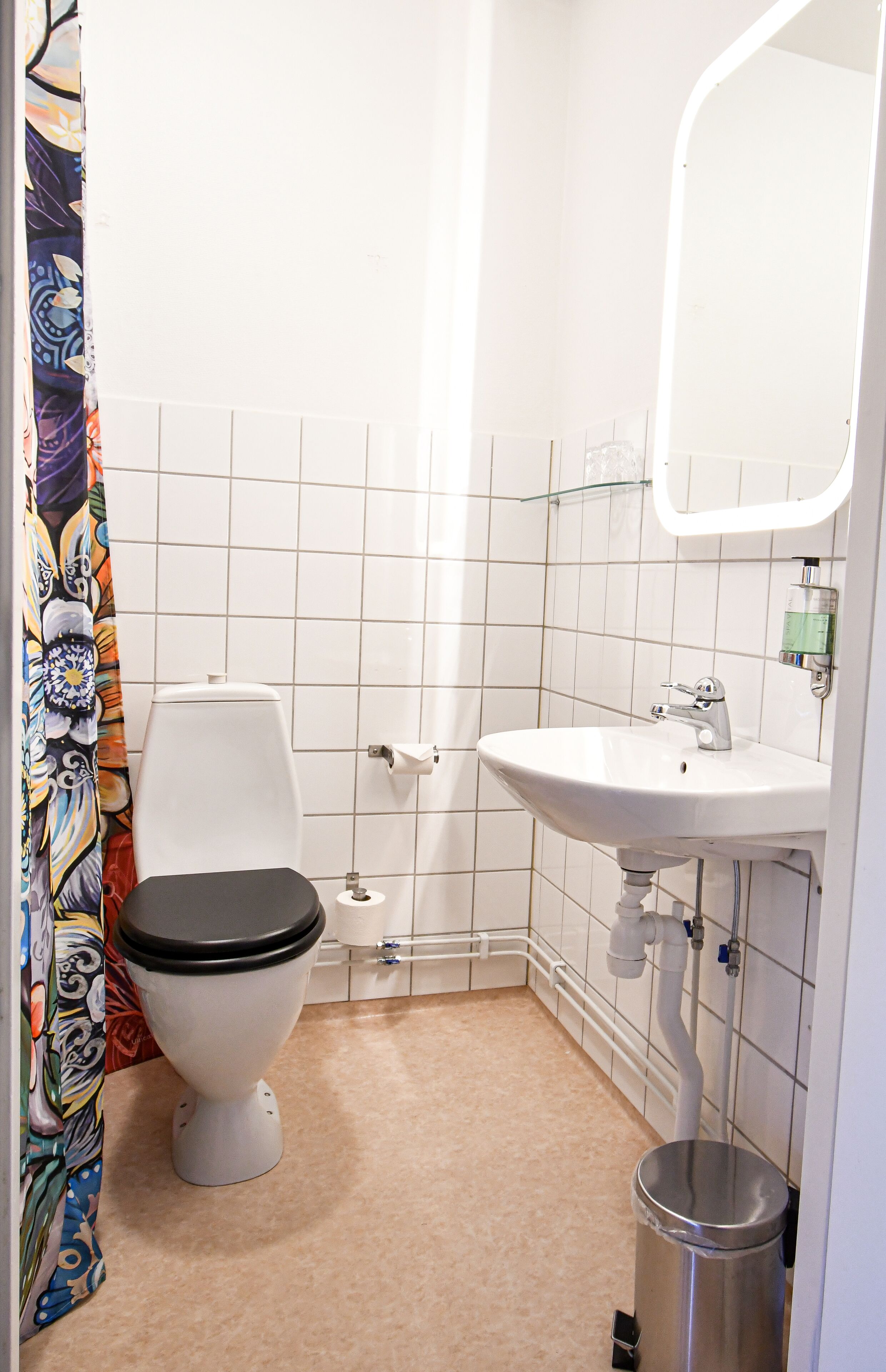 Une salle de bain avec des toilettes, un lavabo et une douche.
