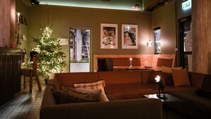 Un ambiente acogedor con un árbol de Navidad, un banco de madera y un sofá con cojines.