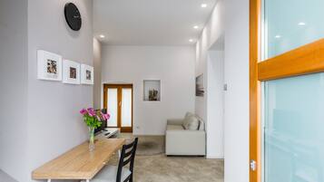 A modern interior with a dining area, a sofa, and a glass door.