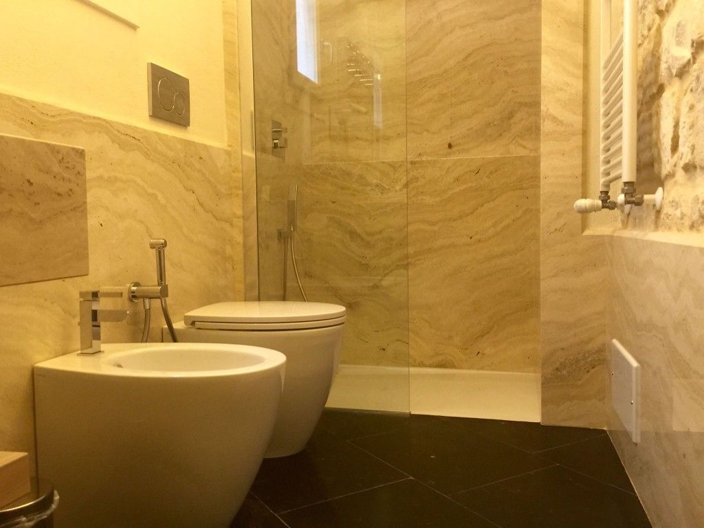 Un baño con dos inodoros, un lavabo y una zona de ducha.