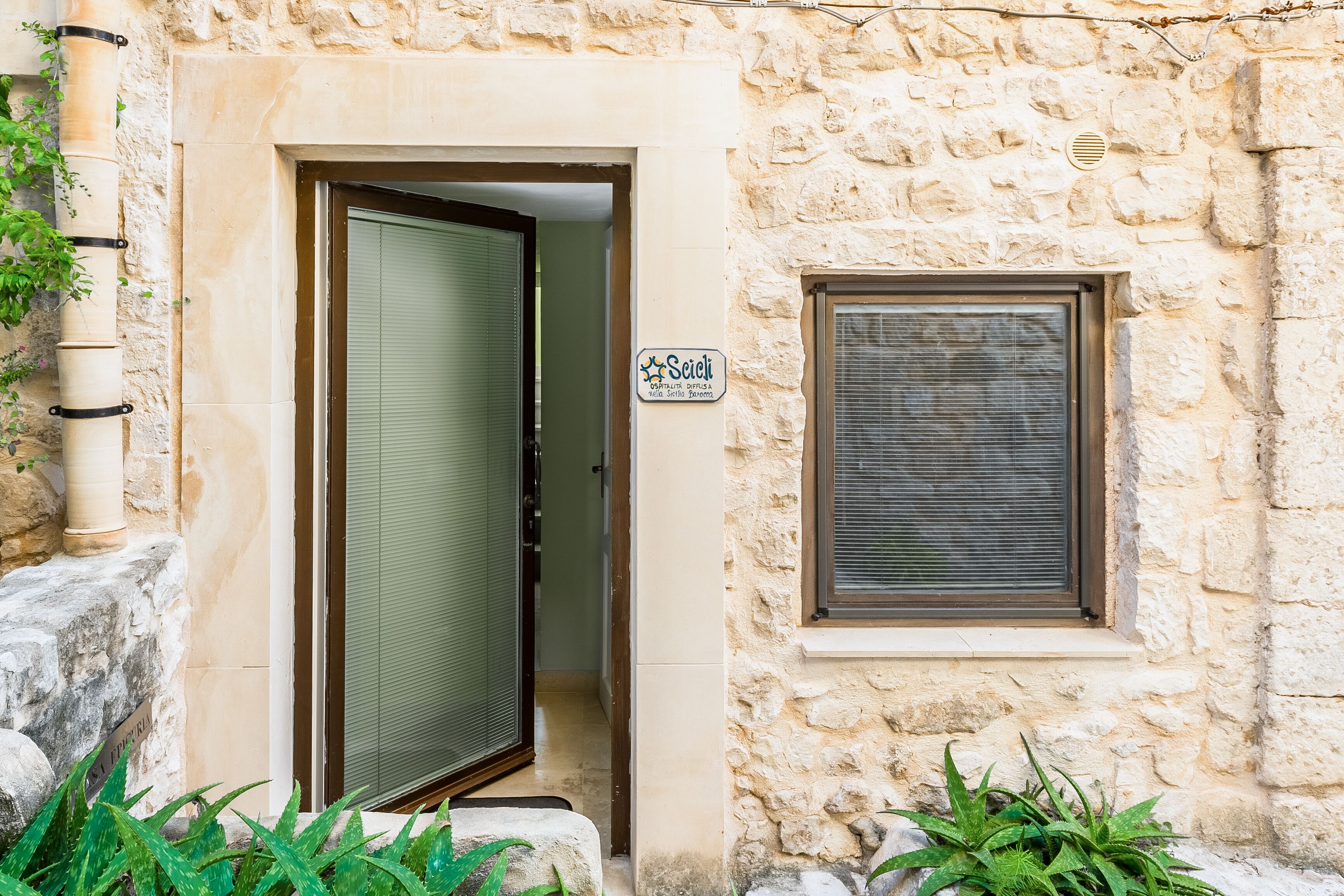 A stone building with a door and a window.
