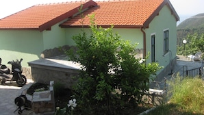 A single-story building with a red-tiled roof, a small porch, and a stone wall. - Agriturismo l'Ulivo e il Mare (Moneglia)