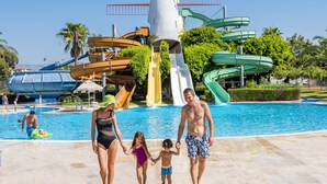 Ein Wasserpark mit einem großen Schwimmbecken, mehreren Wasserrutschen und einer Leuchtturm-Architektur.