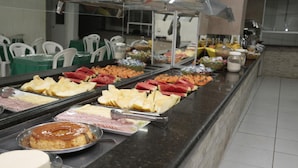 Ein reichhaltiges Buffet mit verschiedenen Speisen, darunter Obst, Käse und Desserts.