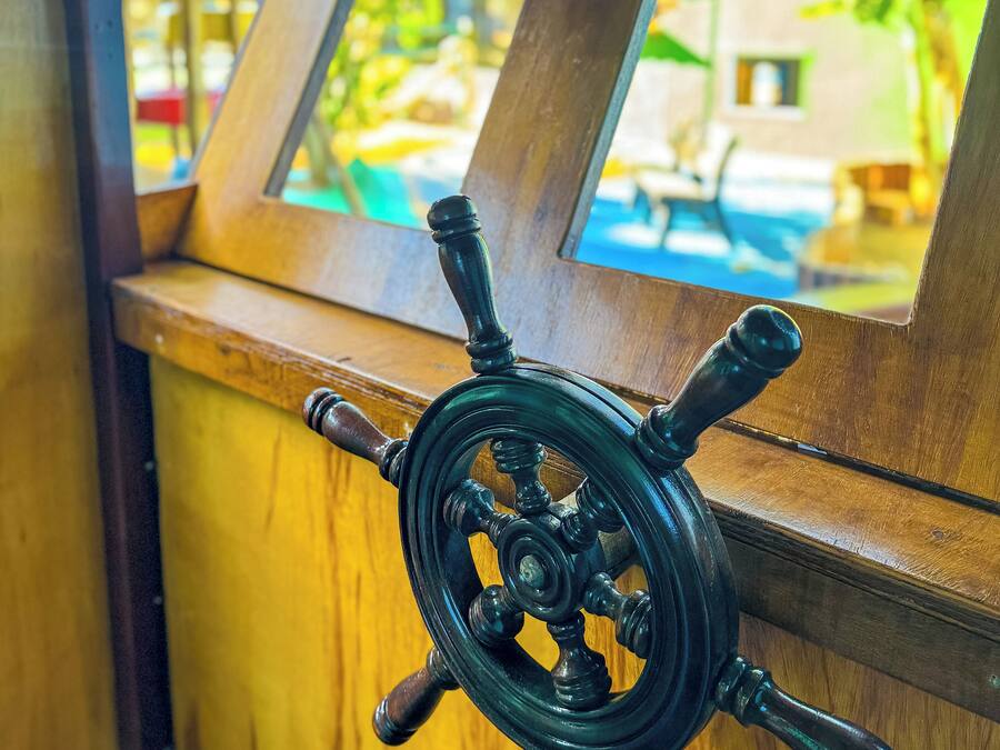 A close-up of a ship's wheel, indicating a nautical theme.
