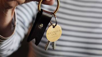 Una persona sostiene un juego de llaves con un llavero que dice 'Harbour Inn'.