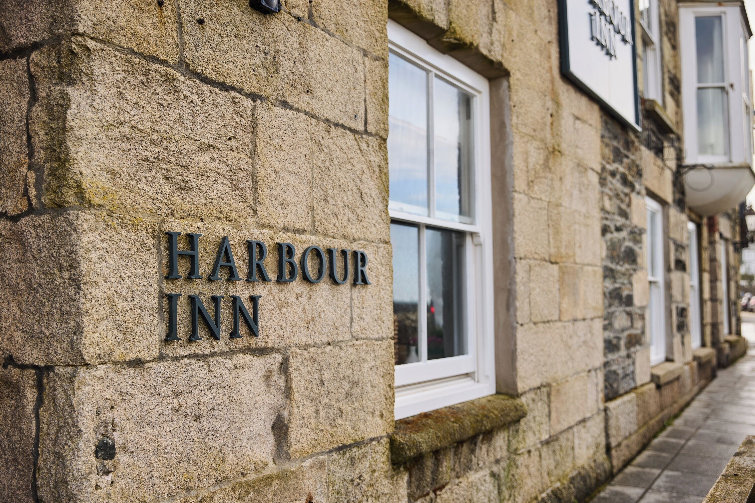 A stone building with a sign reading 'Harbour Inn'.