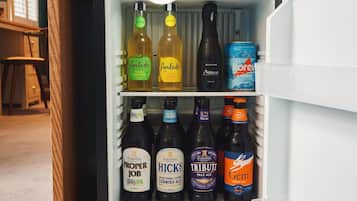 A mini-fridge stocked with various beverages including beers and ales.