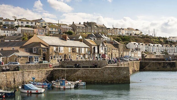 A coastal town with stone buildings, a stone quay, and boats docked.
