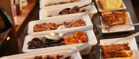 A buffet with various food items and utensils.