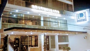 A modern hotel with a glass facade, a visible staircase, and a sign indicating it is a hotel. - Hotel León Dorado (Bucaramanga)
