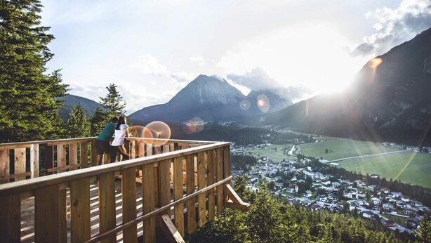 A wooden deck overlooking a valley with a mountain in the background. - Appartement Ausserladscheider (Leutasch)