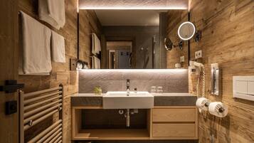 A modern bathroom with a wooden wall, a sink, a mirror, and a towel rack.