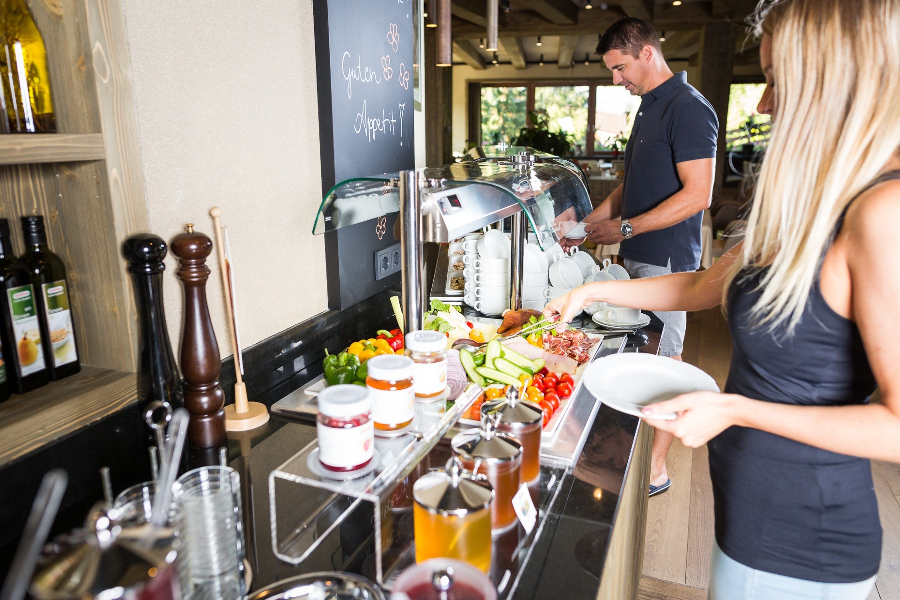 A bar area with a coffee machine, a variety of condiments, and a selection of fresh vegetables and fruits.