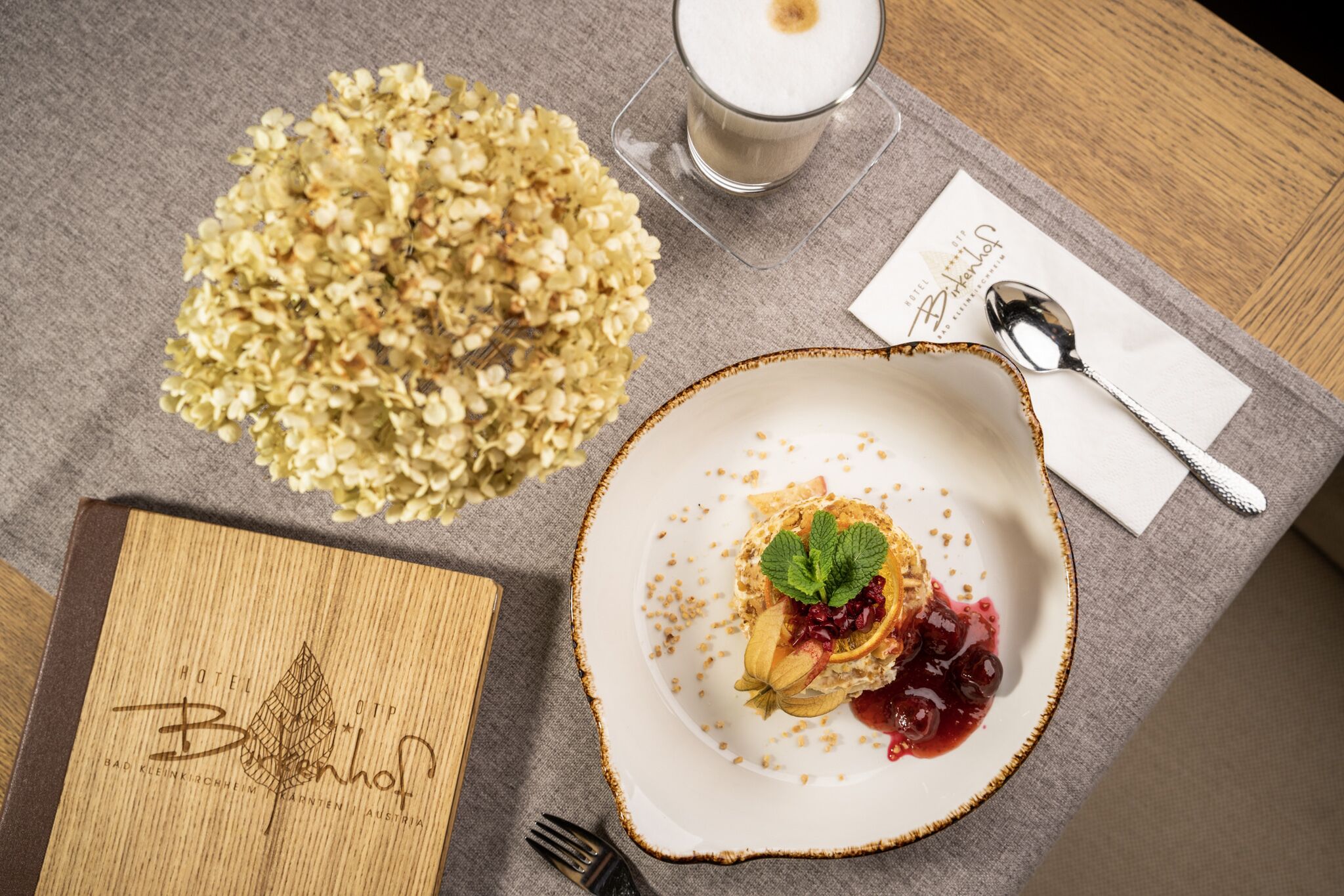 Una mesa dispuesta con un plato de postre, un vaso de leche y un tazón de cereal.